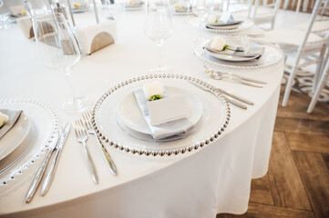 A very beautiful festive table with candles, plates and glasses. Cool room decor