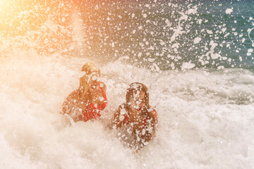 Obraz premium Women ocean play. Seaside, beach daytime, enjoying beach fun. Two women in red swimsuits enjoying themselves in the ocean waves.