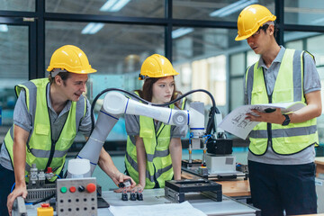 Trainees programing robotic arm in practical lesson at robotics academy, focusing on hands-on skills