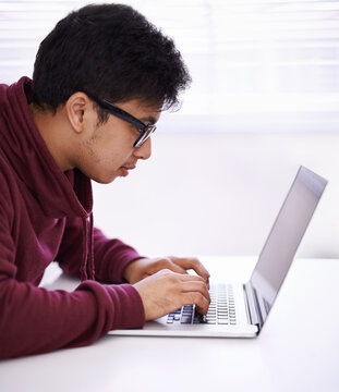 Man, Focus And Typing With Laptop For Research, Development Or Creative Startup On Table At Office Desk. Male Person, Nerd Or Young Geek With Vision On Computer For Email, Networking Or Communication