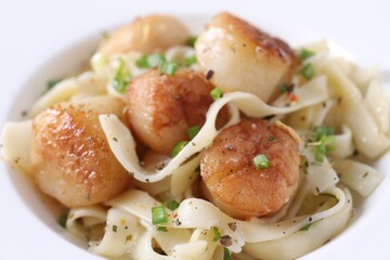 Delicious scallop pasta with spices in bowl, closeup