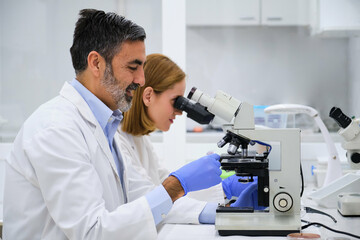 Scientists conducting research investigations in a medical laboratory, researcher using a...