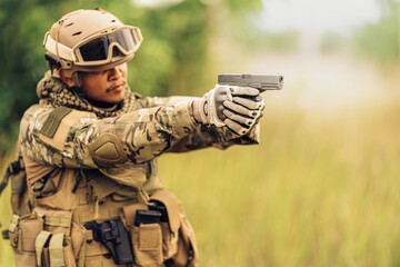 An American soldier carries a loaded handgun, aims and shoots enemies on the battlefield, and has...