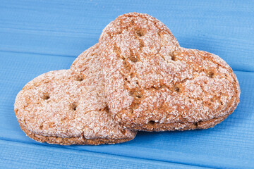 Fresh wholegrain bread in shape of heart for breakfast. Blue boards