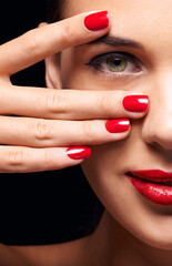 Portrait, red lips and half face of woman in studio with makeup, trendy and beauty routine. Nail polish, hand and female person with facial cosmetics treatment and manicure by black background.
