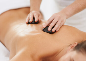 Relax, hot stone massage and woman with therapist at spa for health, wellness and luxury holistic...