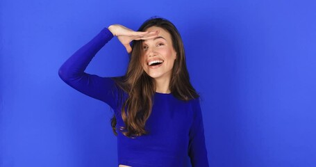 Curious girl in blue long sleeves top holding hand over eyes and looking far away with attentive view, ambitious student making plans for future, watching perspectives, look happy, positive emotions.