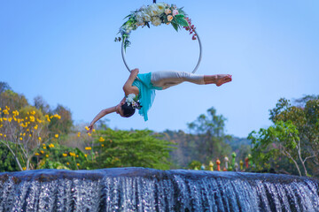 Beautiful Asian girl performing show aerial hoop or aerial ring in various positions and spinning...