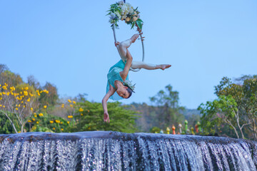 Beautiful Asian girl performing show aerial hoop or aerial ring in various positions and spinning...