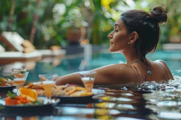 Poster Healthy woman lounging by pool at tropical resort - Leisurely lifestyle of a woman relaxing by a pool in a luxurious tropical resort, surrounded by sumptuous food and drinks. © Postproduction