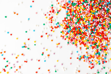 Colorful confectionery sprinkles on white background. Decoration for cake and bakery. Top view 