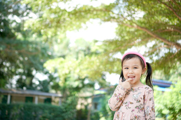 Happy little girl playing at park. Nature background. Copy space.	