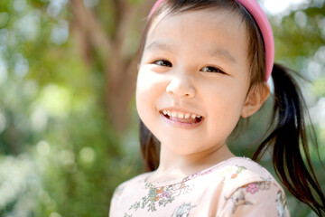 Happy little girl lonly at park. Nature background. Copy space.	