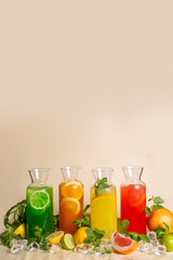 Assorted cold lemonades in glass jugs on an ochre background. photos for the menu