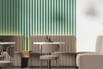 Stylish modern cafe interior with chairs and table with couch, green wall
