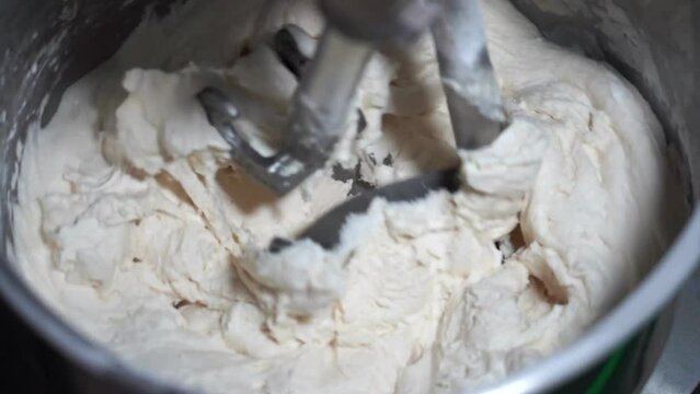 4K Movie of Flour, White Eggs and Water in dough mixing machine, bakery ingredient mixed in the machine 