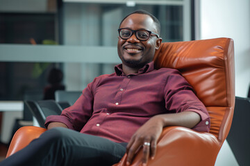 Portrait of a smiling young African American businessman wearing a shirt and sitting on a office chair in minimal workplace background, professional confident young man seated in office, man in office - obrazy, fototapety, plakaty