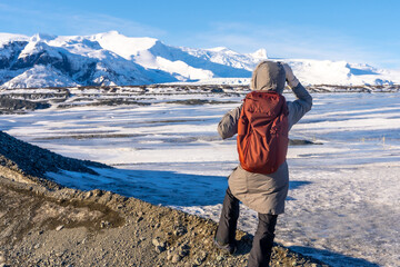 A woman visiting Iceland in winter on the Breidarlon glacier next to Jokulsarlon