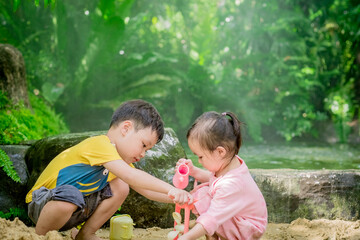 Asian child boy and girl playing toys and sand with natural background. Fine motor skills development for little child. Soft focus. Copy space.