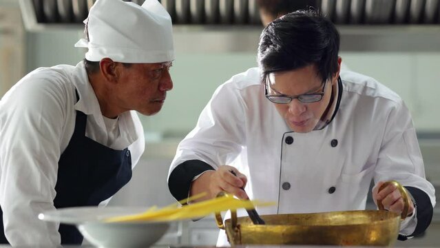 Mature master chef and student. Cooking class. portrait senior asian thai male professional chef cooking meal. culinary classroom. cooking school. lessons in a cooking school.