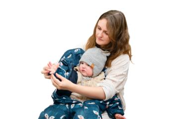 Mother puts a warm scarf on the toddler baby, isolated on a white background. Woman mom dressing warm clothes on child for winter walk in cold weather. Kid aged one year and three months