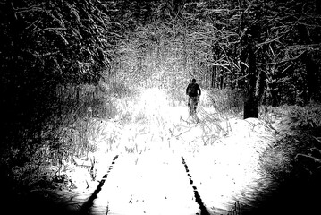 WINTER ATTACK - An old railway road covered with snow and a cyclist on forest road