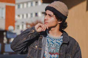 young man with thoughtful gesture in the city