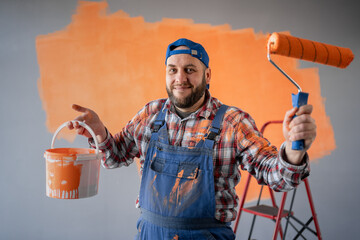Portrait of happy male house painter worker with painting roller