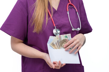 Lekarka w pracy trzyma w dłoni kopertę z polskimi pieniędzmi  - obrazy, fototapety, plakaty