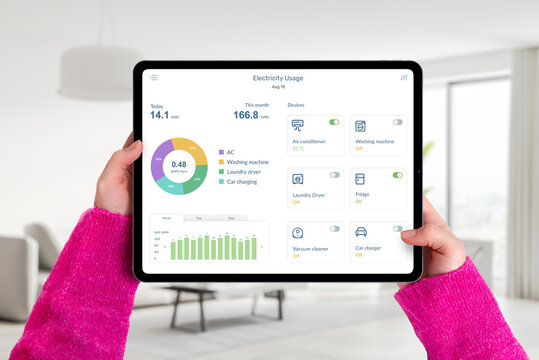Hands hold tablet in living room with electricity usage app, monitoring consumption and controlling home devices. Concept of smart energy management