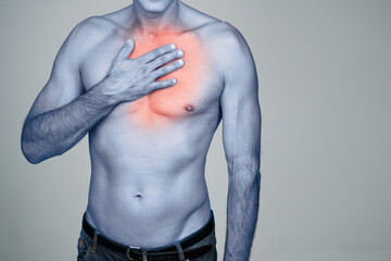 Hand, chest pain or man with heartburn in studio with inflammation, discomfort or injury space. Red...