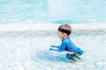 Happy little boy learning to swim. Selective focus. Copy space.	