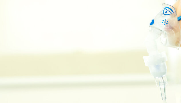 Little asian boy making inhalation with nebulizer at hospital. Decreasing resistance in the respiratory airway and increasing airflow to the lungs. The boy is getting bronchodilator. Copy space.