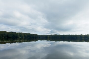 ICM abstract of landscape view of lake, forest and sky with cloudy sky reflection water surface.