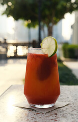 Chill and Refresh with a Poolside Fruit Mocktail. A cool, refreshing fruit mocktail garnished with lime on a poolside table during a relaxing summer day. Vertical photo