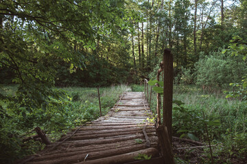 An old wooden bridge in a village over a dry river. Old bridge made of logs. Village summer...
