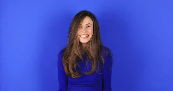 Amazed excited woman win in lottery in pink long sleeves top open mouth in surprise looking at camera with big eyes, shocked isolated on blue background. Oh my god wow, yes gesture, win symbol.