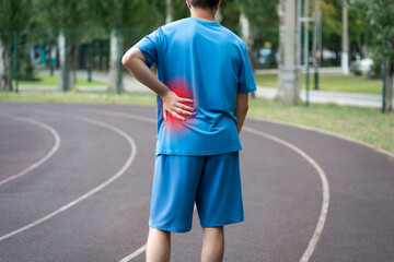 Back pain, kidney inflammation, man suffering from backache on a sports ground after workout - 754200121