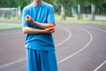 Diseases of the elbow joint, bone fracture and inflammation, athletic man on a running track after workout suffering from pain in cubit - 754200149