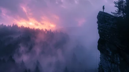 Foto op Plexiglas lone climber rappelling toward the summit of a massive mountain overlooking misty forest at daybreak. volumetric lighting. faint traces of orange and purple in dawn sky. shot with mirrorless camera.  © Emil