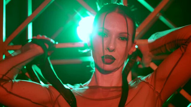 portrait of voluptuous bdsm mistress, with black leather belt in hands, opening mouth seductively