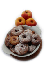 Deep fried apple rings with batter sprinkled with powdered sugar on white background