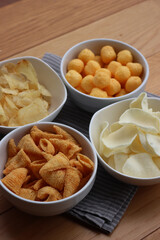 Top view of white ceramic bowls with different kind of chips on wooden table