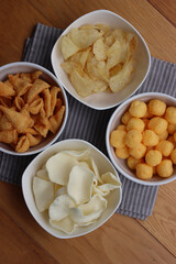 Top view of white ceramic bowls with different kind of chips on wooden table