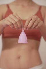 woman wearing underwear White holds a menstrual cup sanitary napkin. white background