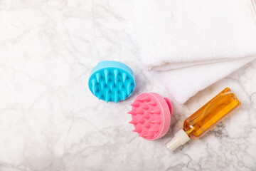 Brush for scalp massage on a marble background. Brush for hair growth stimulating brush. Hair massage. stimulating brush. Hair care, head relaxation concept. Copy space.