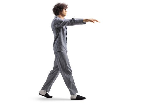 Full length profile shot of a guy in pajamas sleepwalking
