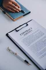 Justice and Law concept. Legal counsel presents to the client a signed contract with gavel and legal law or legal having team meeting at law firm in background