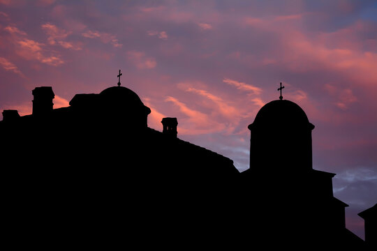 Greek orthodox monastery silhouettes in Byzantine style in sunset