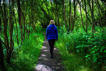A single woman walking through the countryside on a beautiful summer afternoon